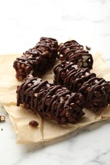 Delicious chocolate puffed rice bars on white marble table, closeup