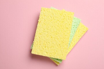 Soft sponges on pink background, top view
