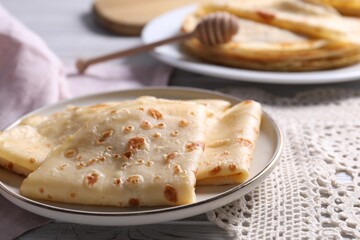 Delicious folded crepes on table, closeup view