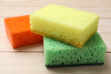 Many soft sponges on wooden table, closeup