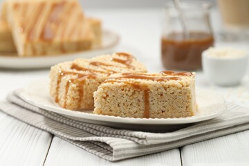 Delicious caramel puffed rice bars on white wooden table, closeup