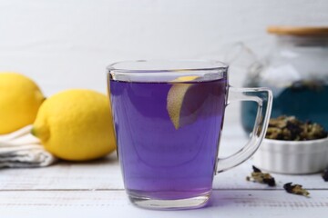 Delicious butterfly pea flower tea on wooden table against white background