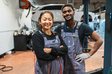 Portrait of confident mechanics smiling in auto repair shop