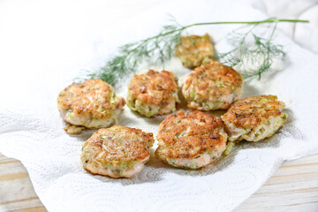 Freshsly fried fish cakes or frikadelles to drain on white kitchen paper and dill garnish, cooking finger food for a party buffet, copy space, selected focus