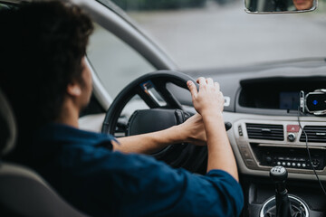 A person driving a car with a focused expression. The image captures the interior of the vehicle,...