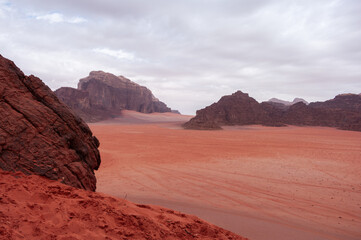A desert landscape with a large rock in the foreground