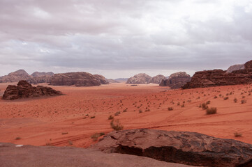 A desert landscape with a rocky outcropping in the foreground