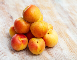 Heap of ripe reddish apricots on wooden table. Concept of health benefits of fruits.