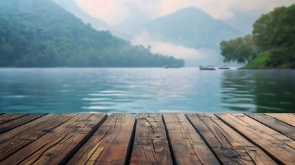 Wooden dock overlooking a misty lake and mountains.