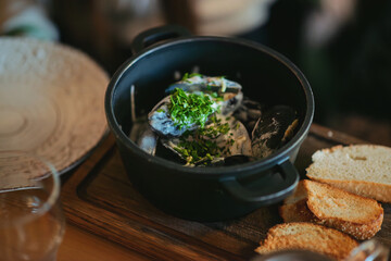 A rustic serving of creamy mussels garnished with fresh parsley, accompanied by crusty bread, embodies coastal elegance and culinary comfort.