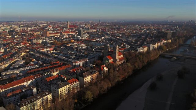Kath. Pfarramt St. Maximilian Katholische Kirche in Munchen, Bayern, Deutschland Luftaufnahme. Aerial view of St. Maximilian in Munich with distinctive towers at sunrise, surrounded by autumn colors. 