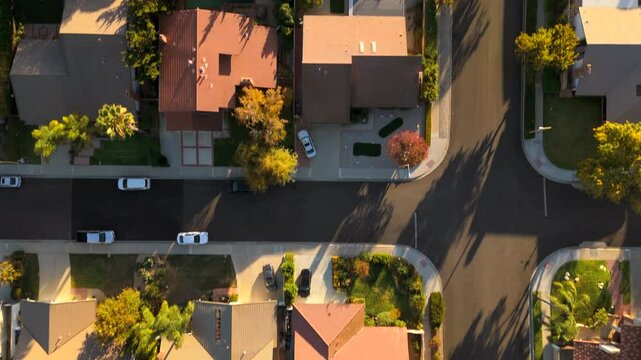 Absolutely stunning aerial view beautifully showcases a serene and tranquil suburban neighborhood in Los Angeles, featuring charming homes bathed in the warm golden glow of a picturesque sunset