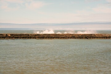 Waves Hitting the Breakwater Concrete Wall on a Sunny Day, Ocean Splashing against Seawall