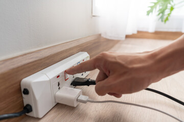 Man is turning off the light switch after not using it, energy saving, saving money, environmental...