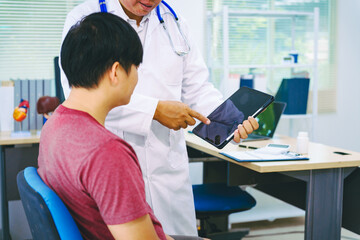 A man suffering from urinary tract infections visits a doctor at the examination table in a...