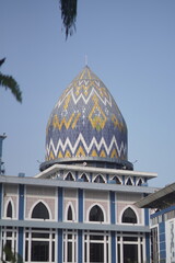 The red and white yellow dome of the mosque with a blue sky background