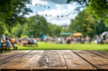Foto op Canvas Wooden table in blurred park festival background. © adri