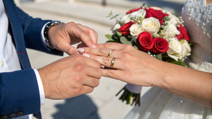 couple exchanging wedding rings during romantic ceremony, surrounded by beautiful flowers