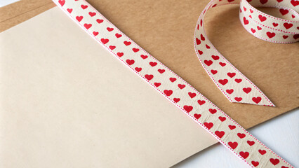 Obraz premium Crafting materials with heart patterned ribbon and brown paper evoke love and creativity. Perfect for Valentine Day projects