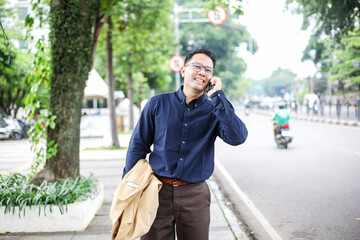 Smiling Businessman Calling Using Smartphone While Walking on Sidewalks