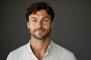 Obraz premium Confident Young Man with Natural Charm and Warm Smile Against a Dark Background