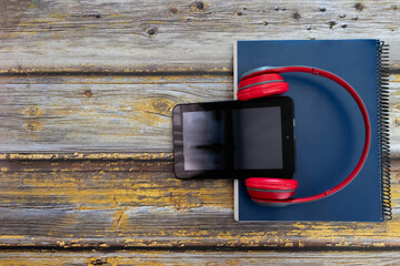 headphones, a tablet and a book, audiobook concept