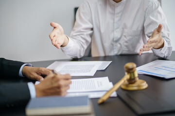 Legal counsel presents to the client a signed contract with gavel and legal law. justice and lawyer concept