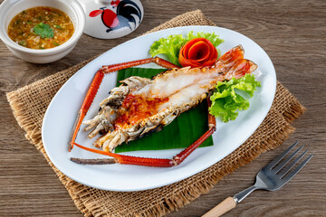 Grilled giant river prawn served on a plate with Thai seafood sauce. Thai cuisine.