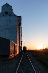 Obraz premium A train is traveling down a track next to a grain silo