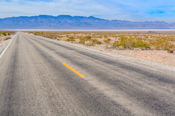 A long, empty road with a yellow line down the middle