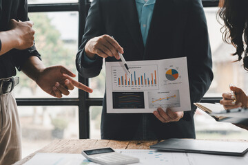 Business colleagues reviewing sales performance data, using charts and graphs to identify trends and make informed decisions for growth
