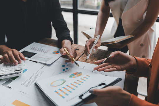 Business team analyzing financial data using graphs, charts and calculator during a working meeting