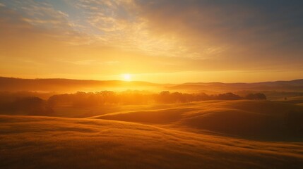 Obraz premium Golden Sunrise Over Rolling Hills and a Misty Forest