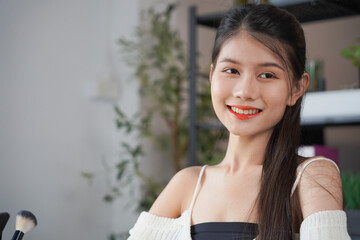 Asian woman influencer beauty blogger live streaming reviews her cosmetics on online platform