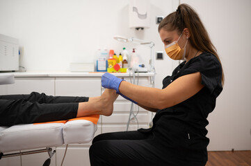 Podiatrist performing foot examination on patient in clinic