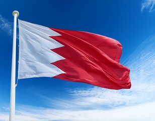 Bahrain flag waving in the wind against a blue sky background