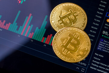 Bitcoin and cryptocurrency investment concept. Golden Bitcoin cryptocurrency symbol standing in front of Bitcoin's rise and fall chart