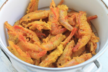 Flour fried shrimp in a bowl on a wooden table

