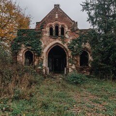 Obraz premium Overgrown Brick Ruin A Gothic Revival Chapel in Decay