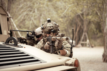 United States Army in camouflage uniforms operation in the forest.with armored vehicle, soldiers...