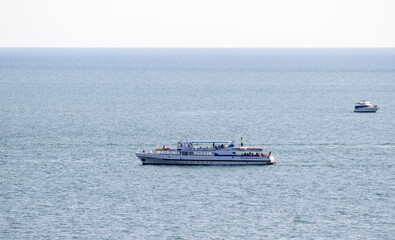 A large boat is sailing in the ocean with a smaller boat in the background