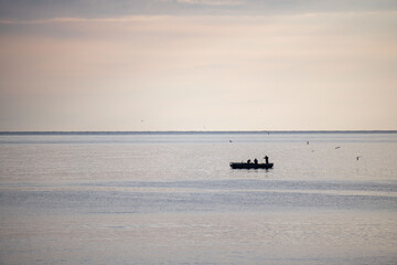 A boat is floating on the water with a man in it