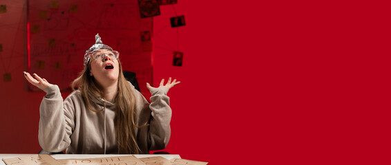 Female conspiracy theorist in protective foil cap and glasses debunks myths angry screaming with...