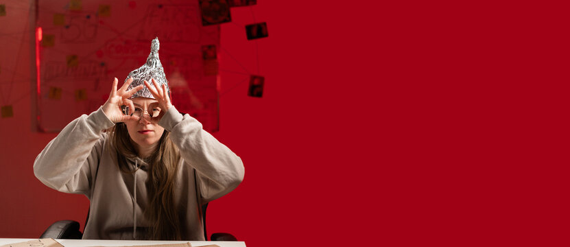 Conspiracy Theory: Crazy myth buster woman recording video in her studio showing binoculars with fingers on eyes