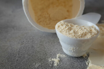 Open container with colostrum powder and measuring scoop	