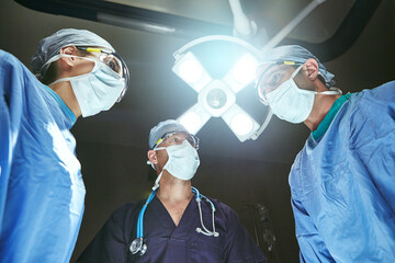 Hospital, surgery and below of team of doctors in operation for emergency, medical service and...