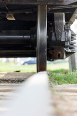 A train wheel is shown in the foreground of a grassy field