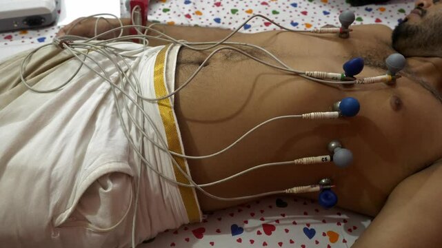 ECG machine electrodes attached to patient's chest, arms, and legs to record heart electrical signals at home space