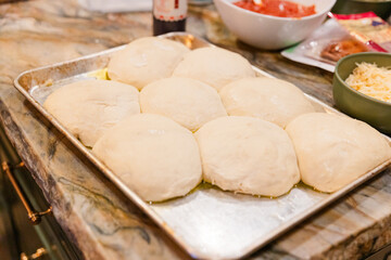pizza dough balls resting on a tray, ready for baking or preparation