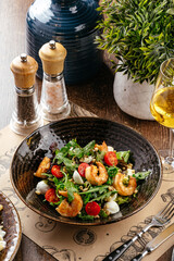 salad with mozzarella shrimp and tomatoes with a glass of wine